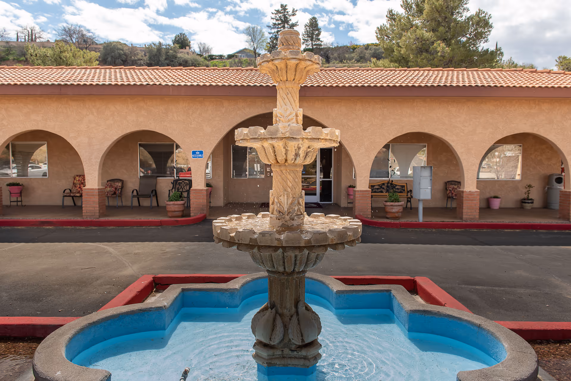 Outdoor courtyard with a fountain in front of arches at Heritage Health Care Center