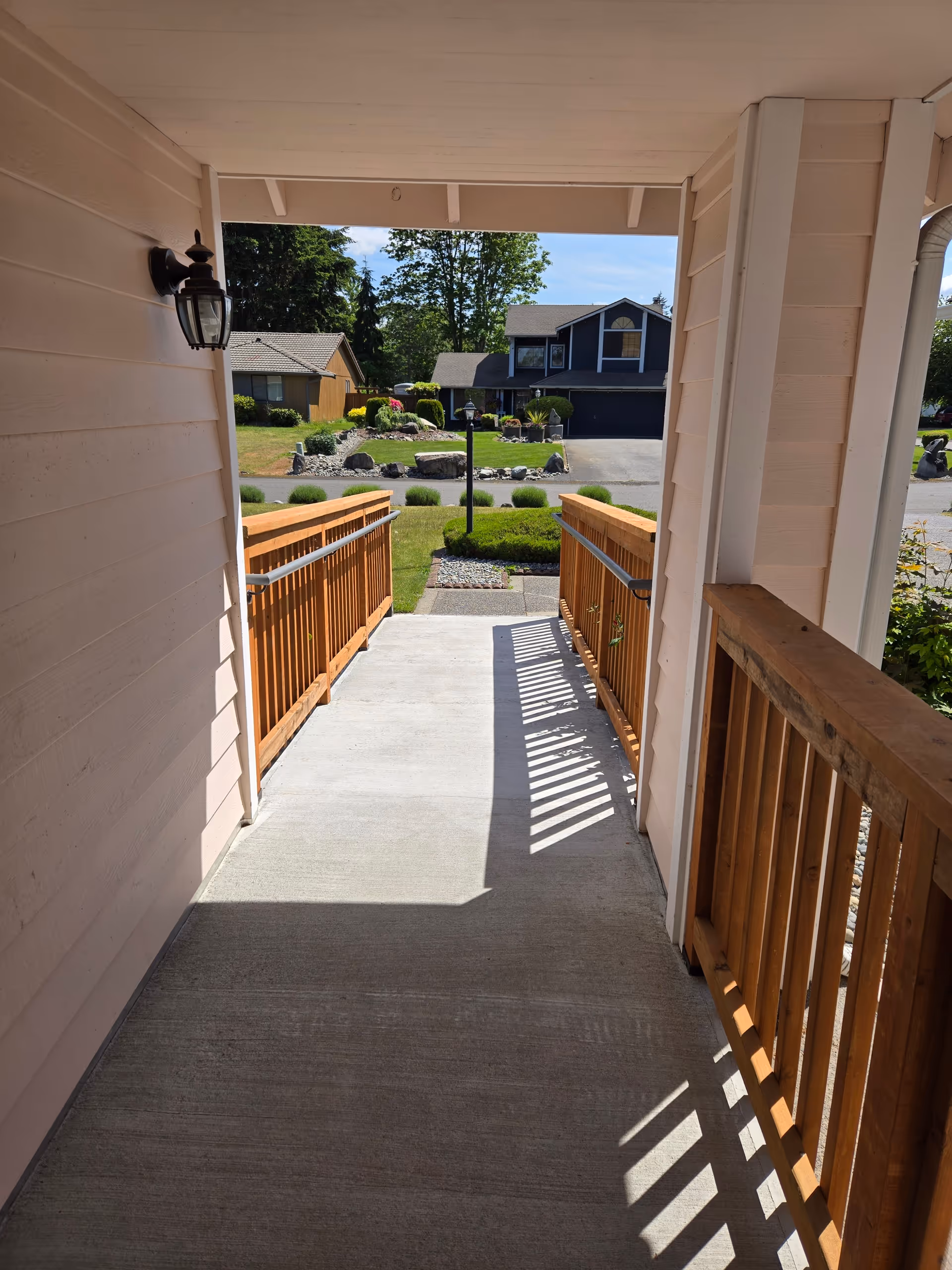 Covered porch walkway to a landscaped street in front of a senior care home.