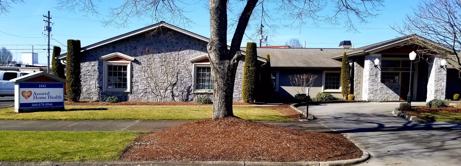 Front exterior view of Assured Home Health of Longview building with sign and driveway