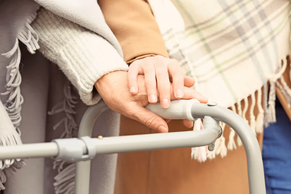 Close-up of hands gripping a walker indoors