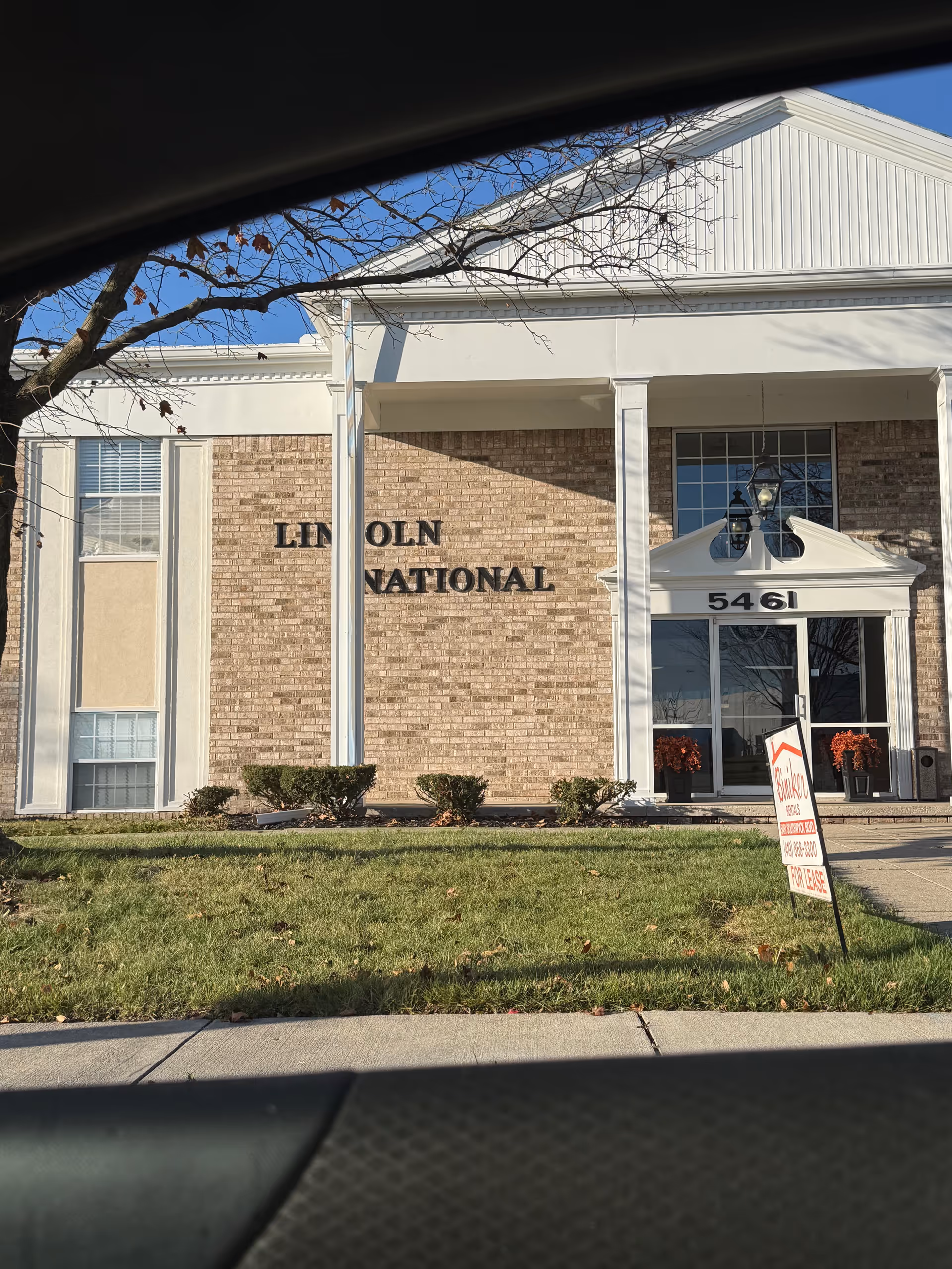Front view of a brick building with a tall entrance and Lincoln International signage.