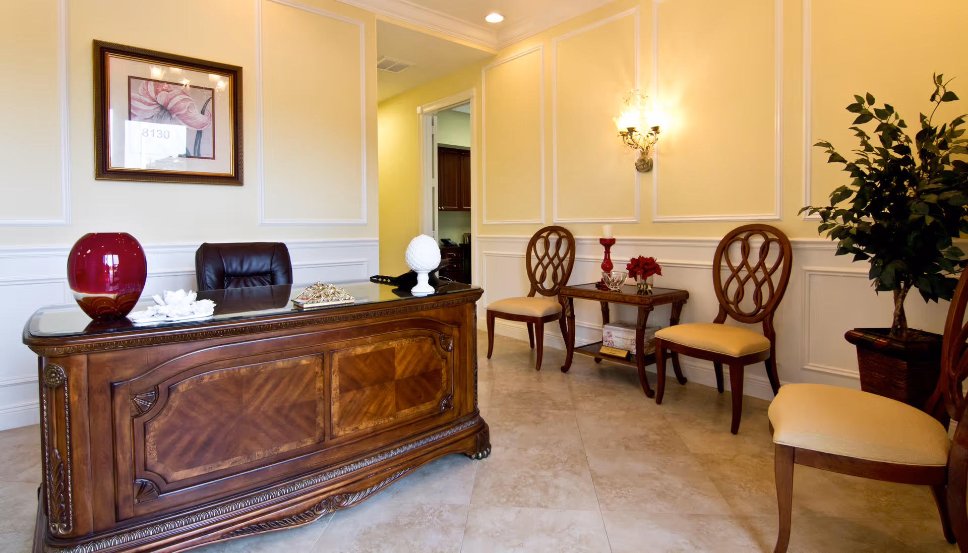 Elegant reception area of Nightingale Private Care, with wooden desk, chairs, and plants.