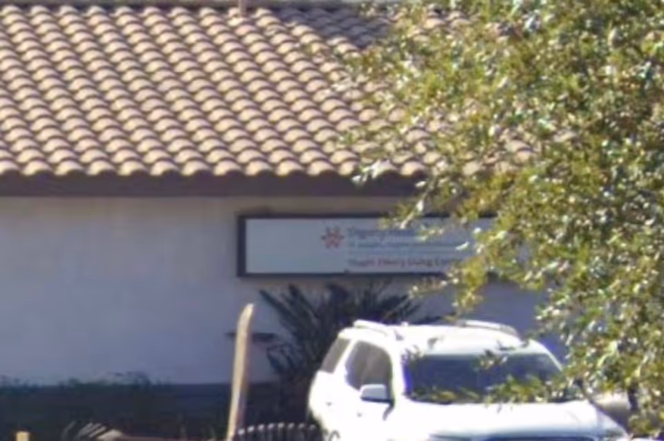 Front exterior of Huger Mercy Living Center with a sign and a parked white SUV.