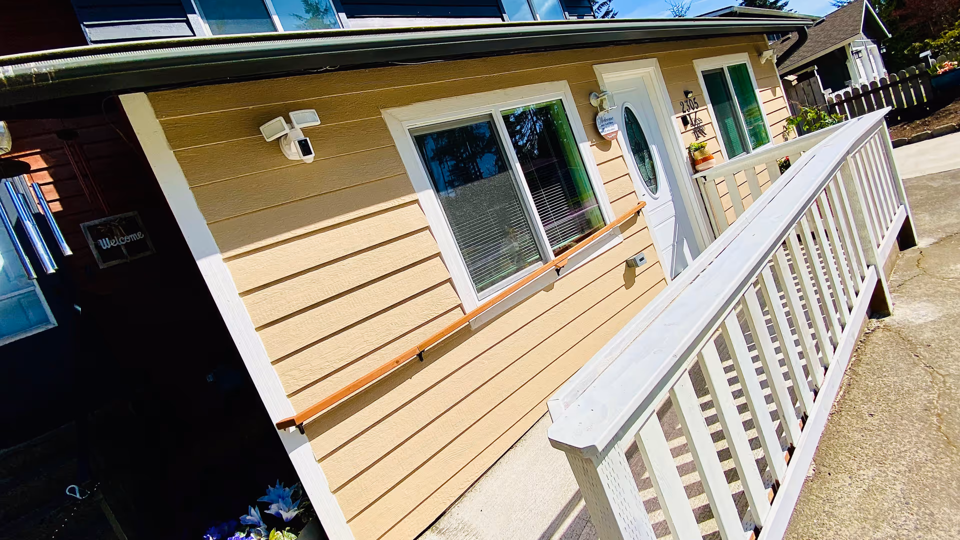 Beige building exterior with white-railed ramp leading to a front door.
