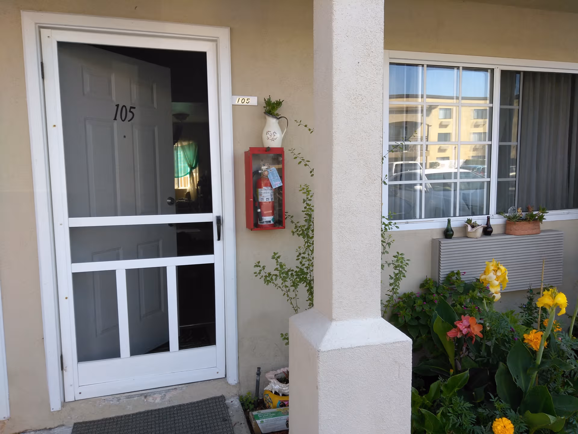 Exterior view of Newport Senior Village entrance with door, window, planter, and garden.