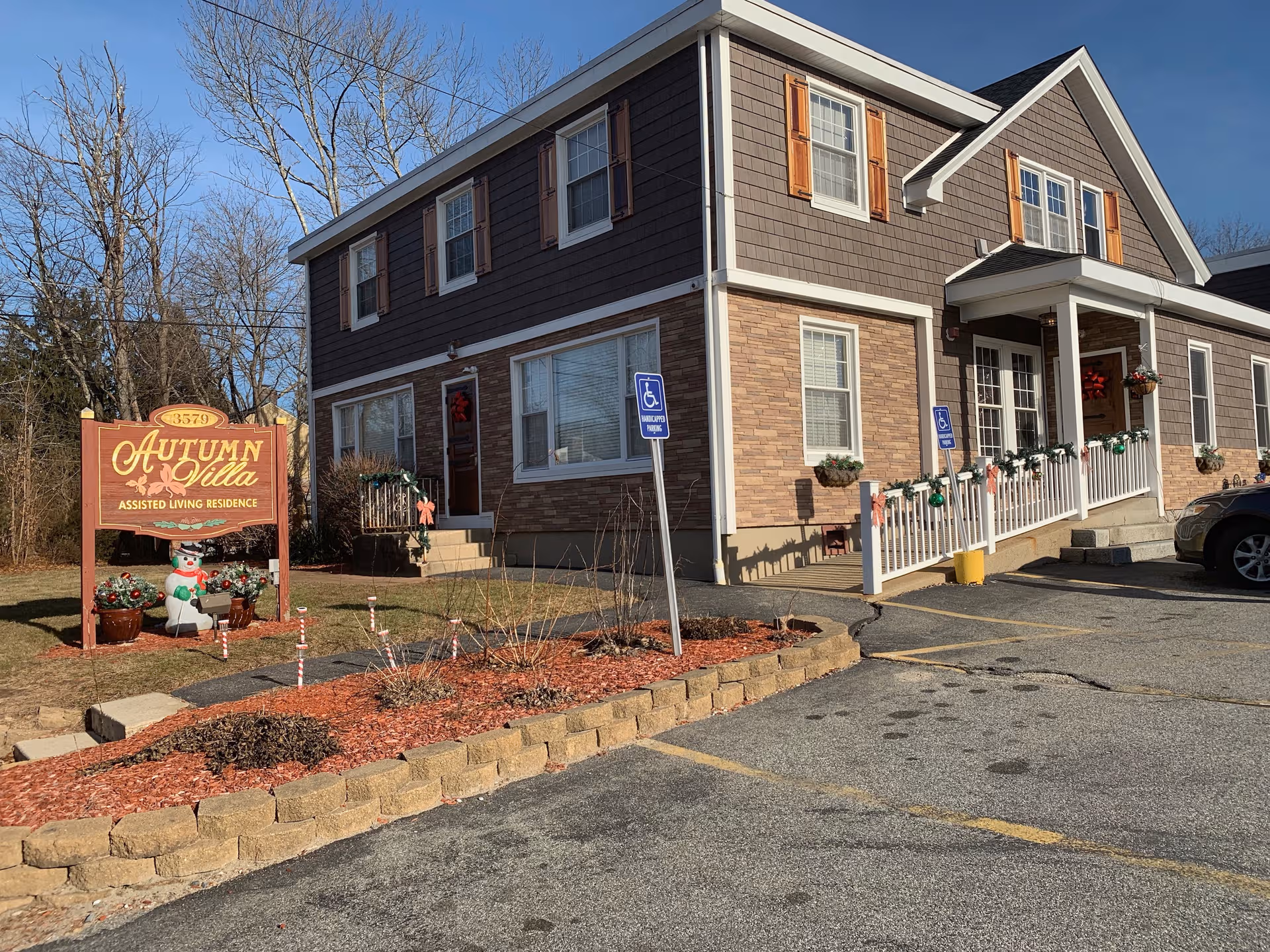 Exterior view of Autumn Villa assisted living facility with handicap parking and festive decor.