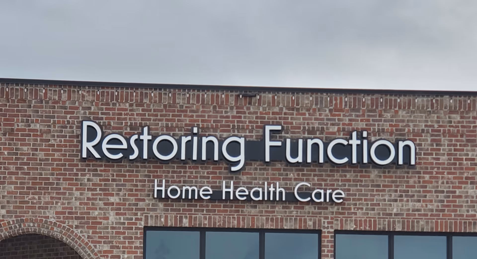 Brick facility exterior with large sign displaying Restoring Function Home Health Care.