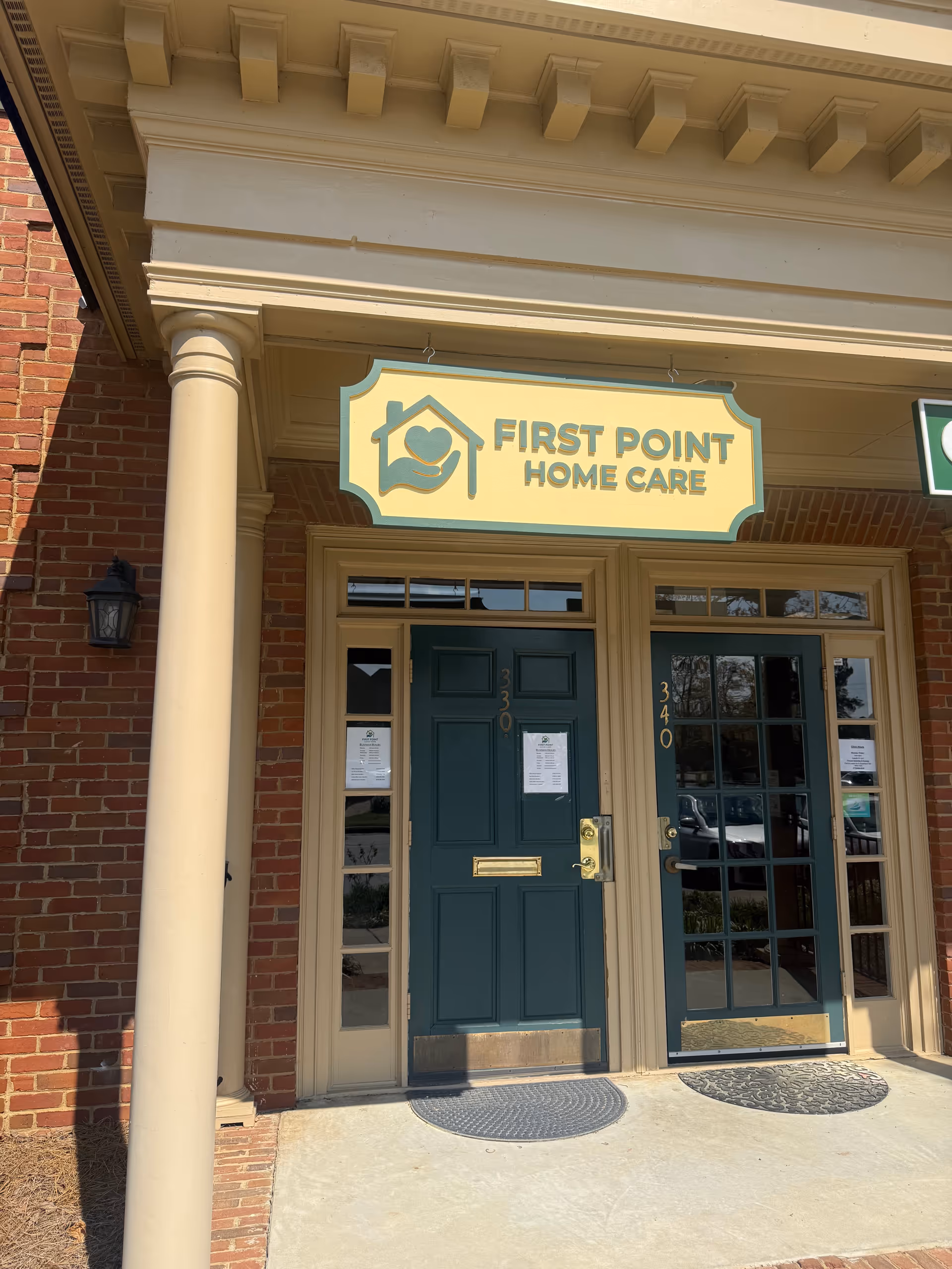 Brick building with teal front doors and a First Point Home Care sign.