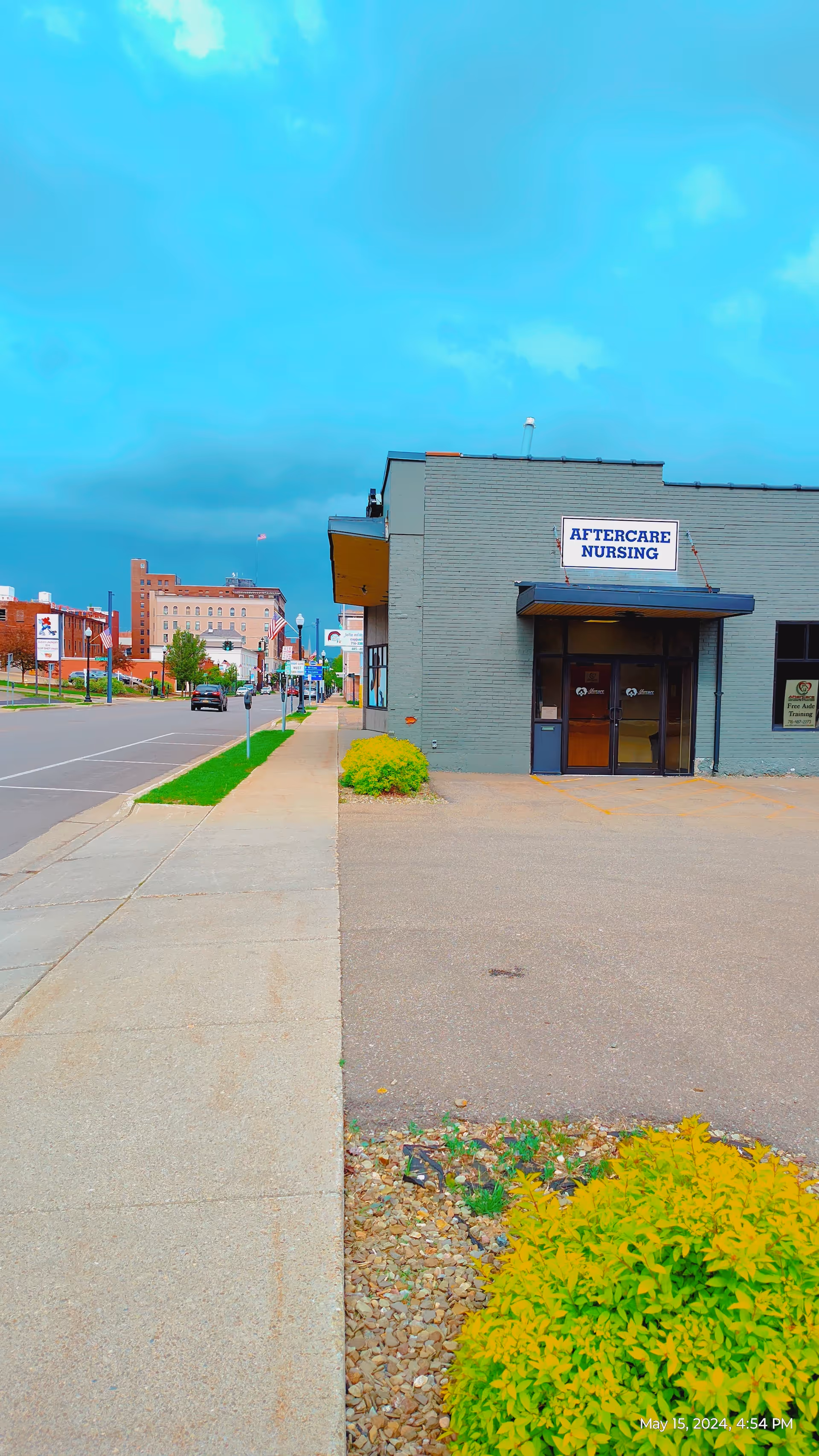 Front exterior of a gray building with an 'Aftercare Nursing' sign and entrance.