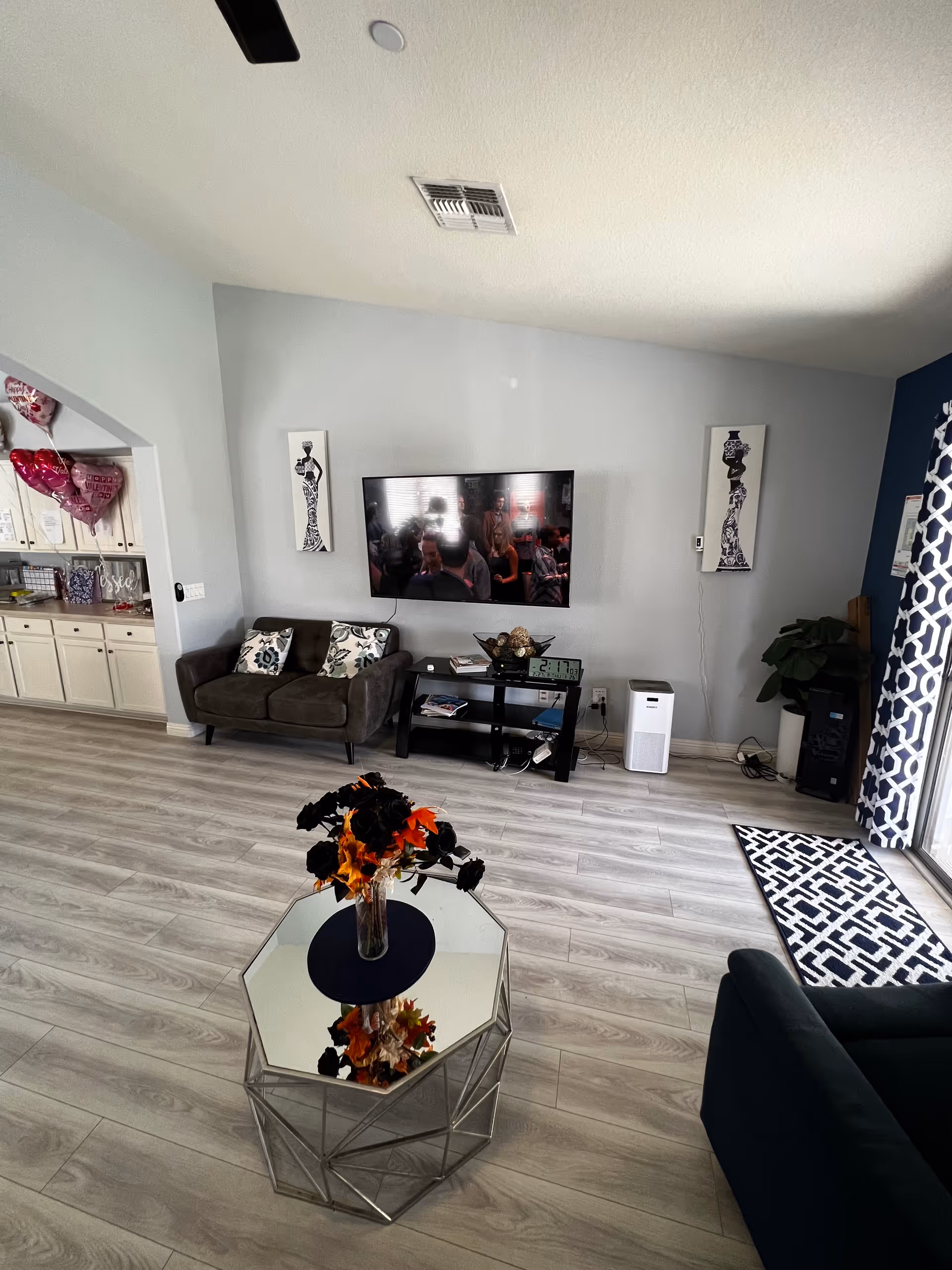Modern living room in senior facility with TV, sofa, coffee table, and art.