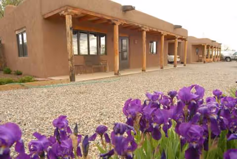 Exterior view of Taos Retirement Village with purple irises in the foreground.