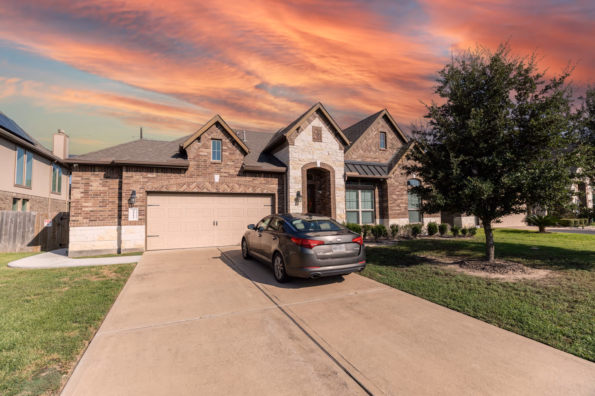 Brick senior living facility with driveway, parked car, and front lawn.