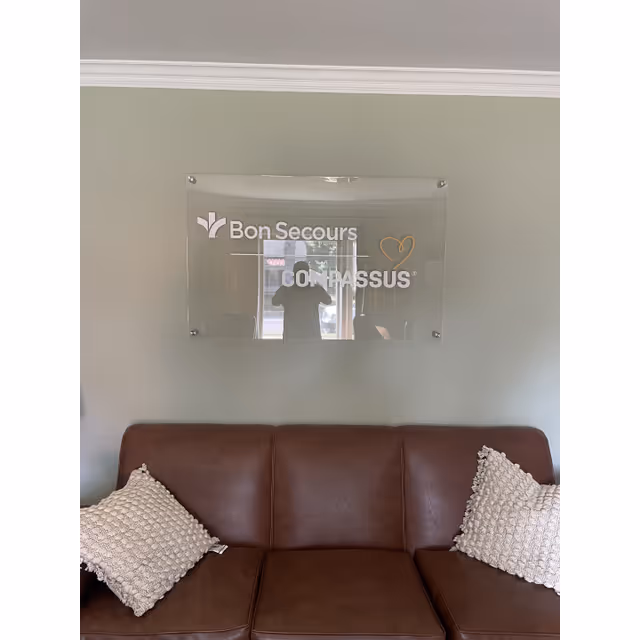 Leather sofa against a pale green wall with a Bon Secours Compassus sign.