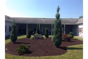 Exterior view of a single-story care home with landscaped front yard and pathway.