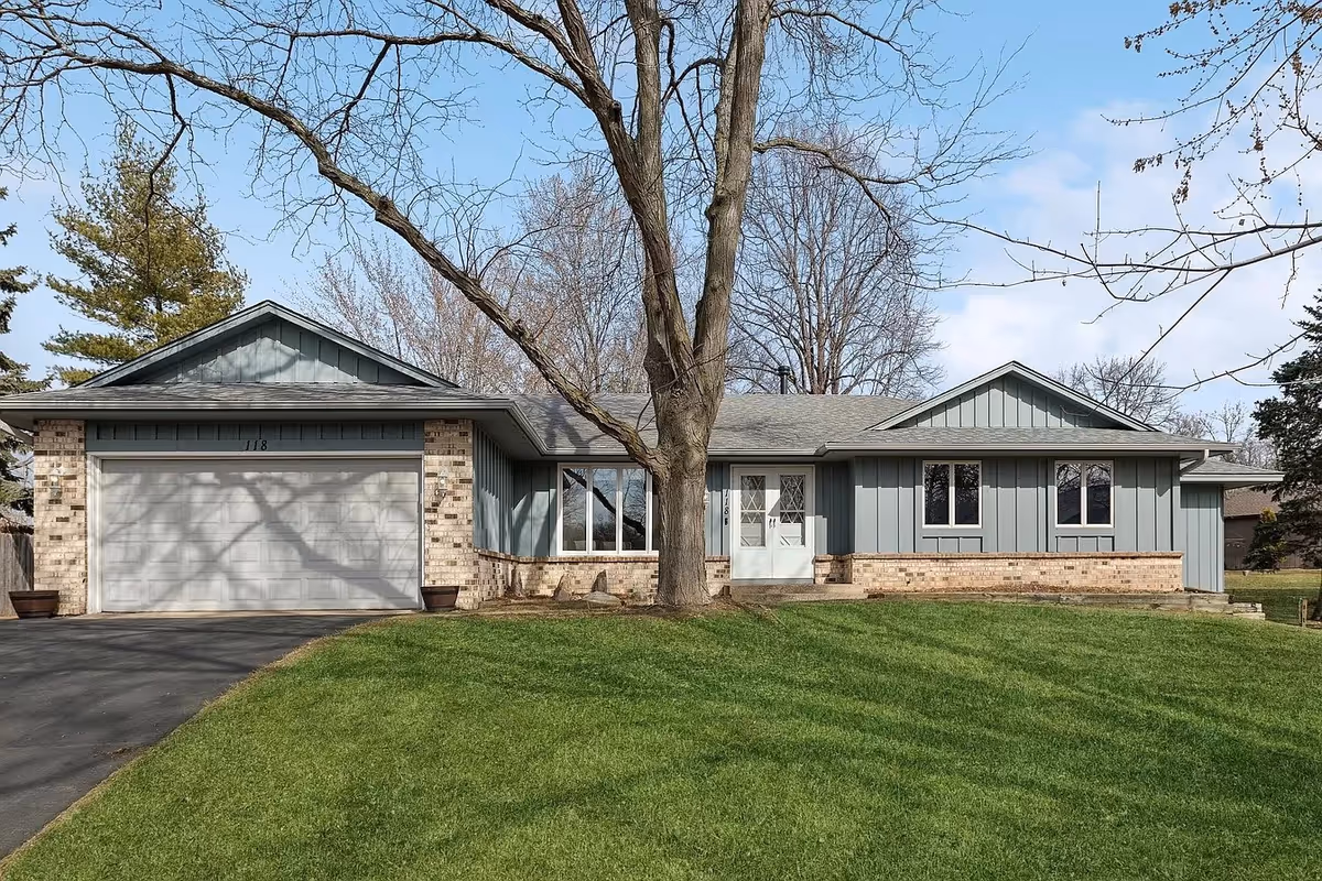Single-story blue-gray building with a two-car garage and manicured lawn.