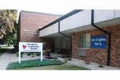 Exterior view of Mendota Lutheran Home entrance with signs and covered walkway.