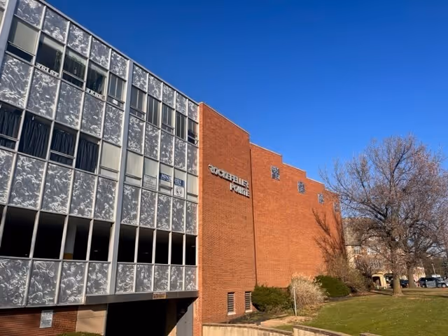 Exterior view of a brick senior care facility with a glass-walled left wing.
