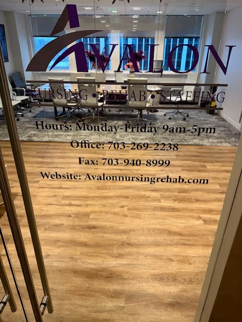 Glass door with Avalon logo and contact info; interior office space behind.