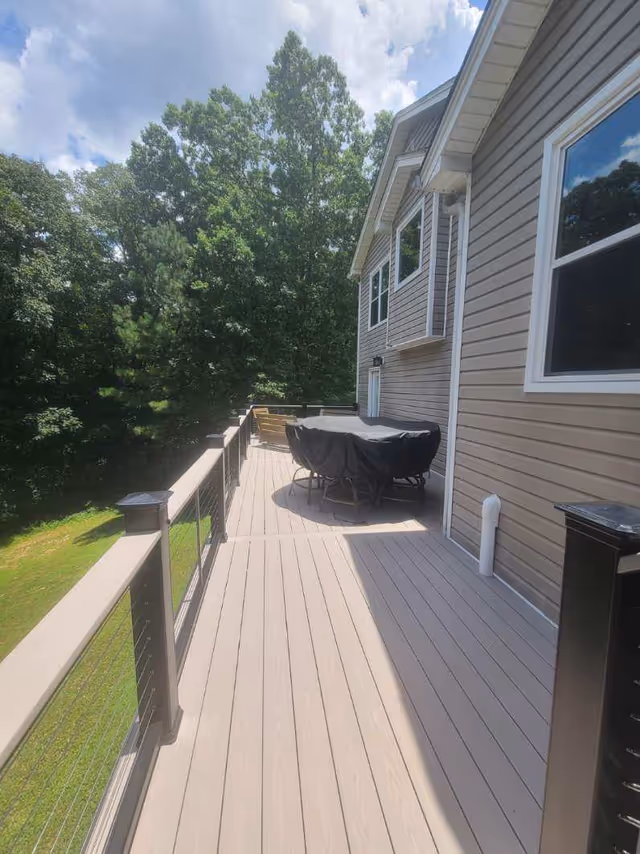 A spacious wooden outdoor deck beside a beige senior living building with seating.