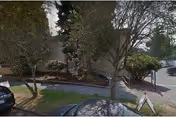 Front exterior of Crystal Springs Senior Care Facility with trees, shrubs, and parked cars.