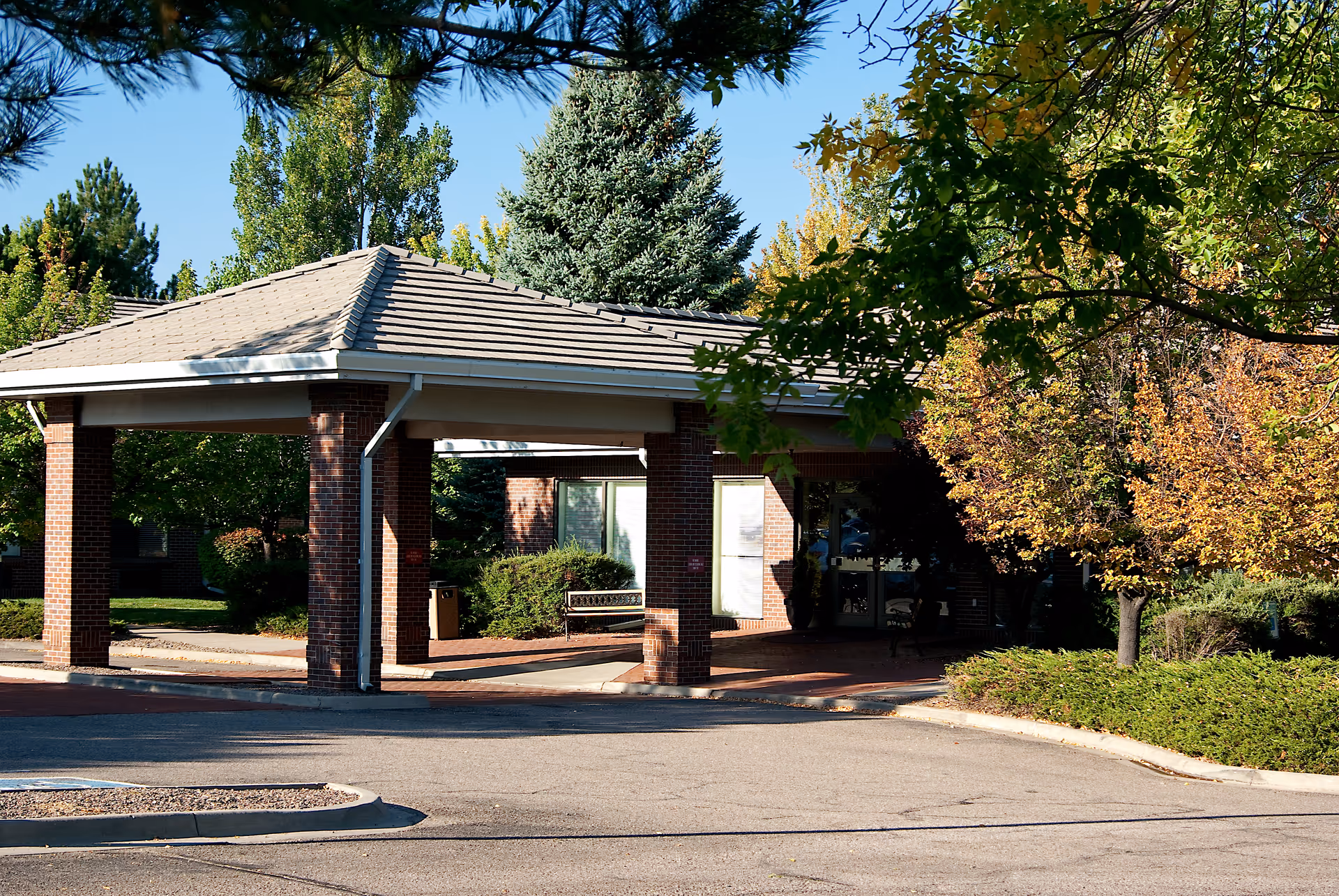 Orchard Park Health Care Center entrance with a covered driveway and trees