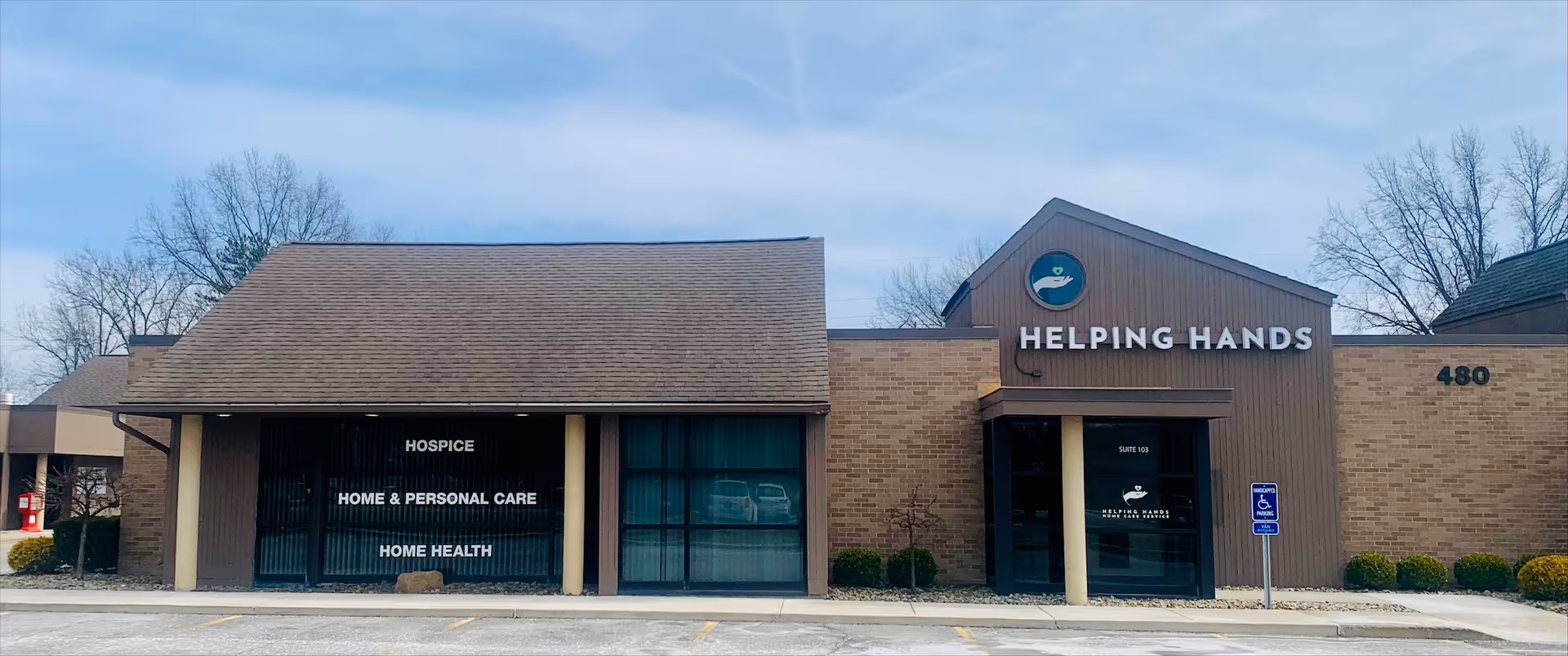 Exterior view of Helping Hands facility with signage and brick front entrance.