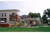 Exterior view of Sunnyview Nursing and Rehabilitation Center with lawn and outdoor seating.