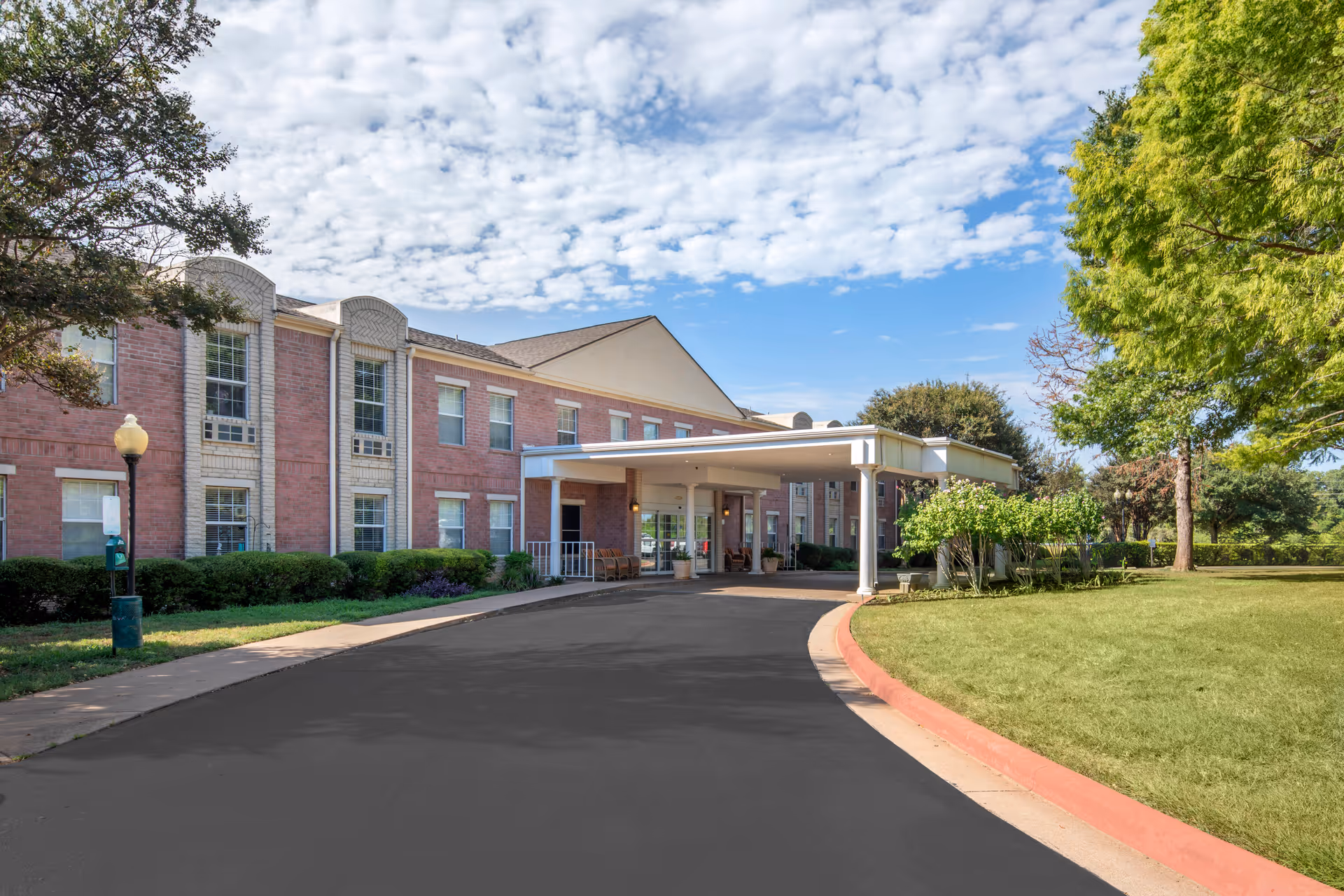 Front view of Brookdale Mariana Butte senior living facility with brick exterior and curved driveway.