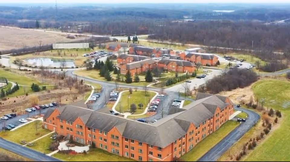 Aerial view of Aliya of Palos Park senior living campus with brick buildings and parking.