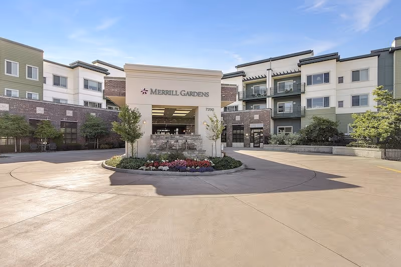 Exterior view of Merrill Gardens at Tacoma, showing the circular driveway and central entrance with landscaping.