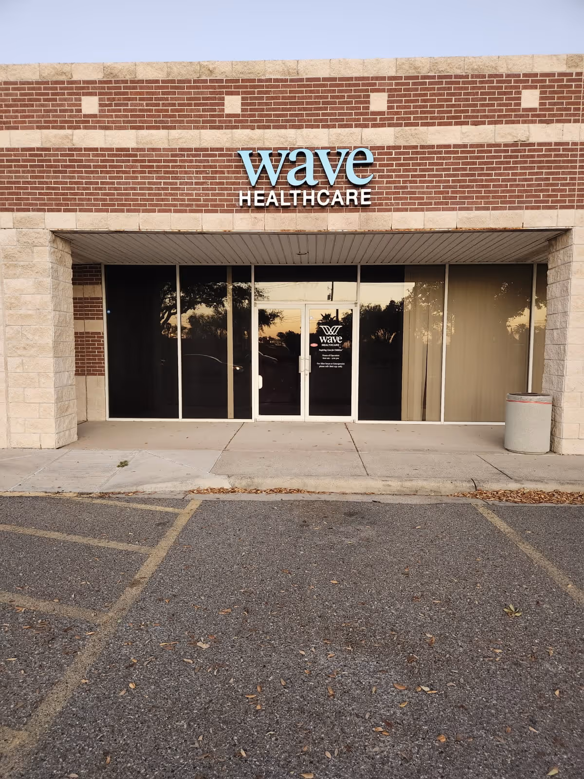 Wave Healthcare entrance with brick facade and glass doors at the building front.