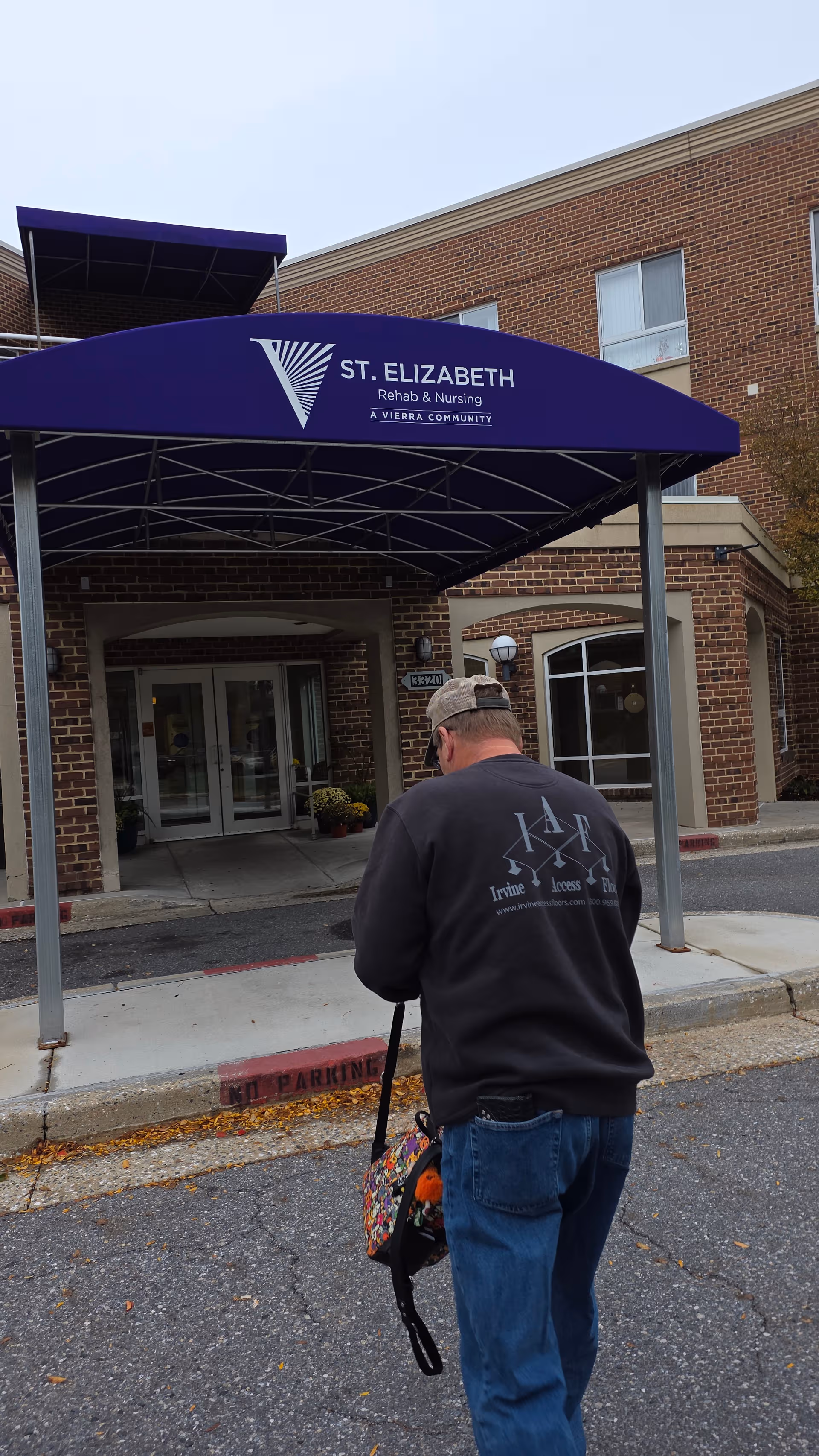 Exterior view of St. Elizabeth Rehabilitation and Nursing Center entrance with a man walking.
