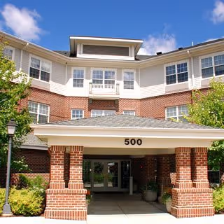 Exterior view of New Perspective Senior Living on Carlson Parkway, brick entry.