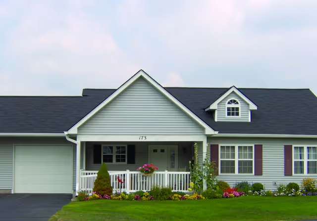 Front view of Seabury Woods senior living facility with a covered porch and garden.