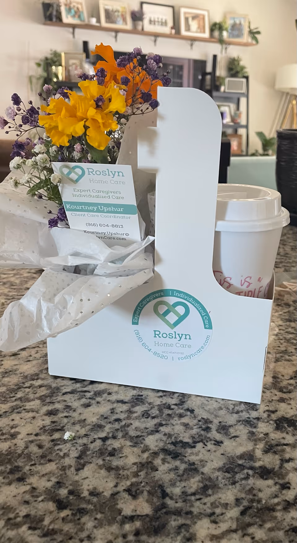 Heart-shaped bouquet in a Roslyn Home Care branded gift box on a marble counter.