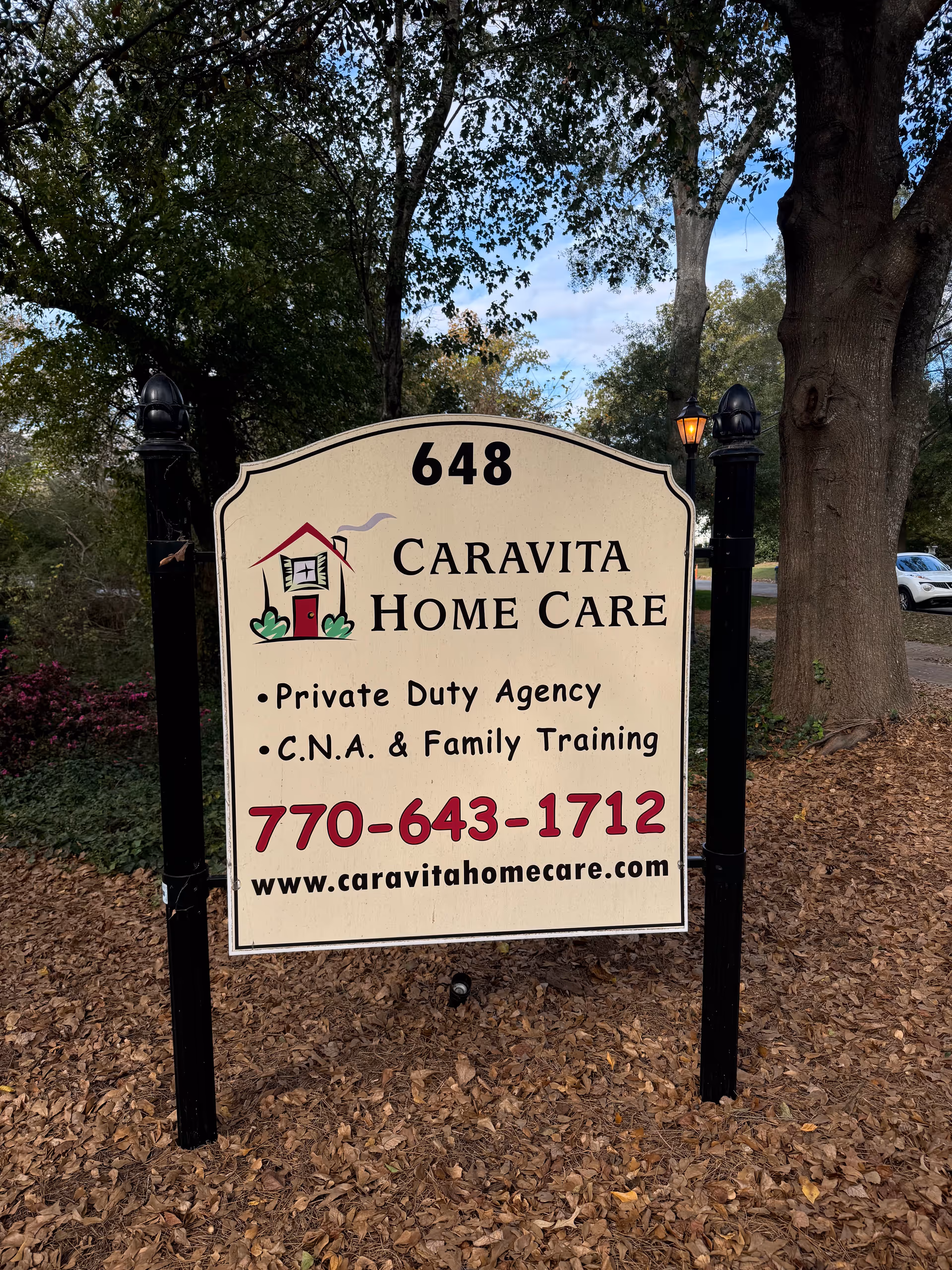 A large outdoor sign reading CaraVita Home Care with services and phone number.