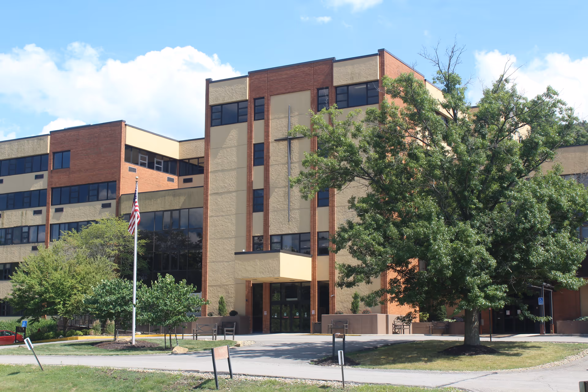 Exterior view of St. John Community building featuring a modern facade, large windows, and a prominent entrance with a cross design.