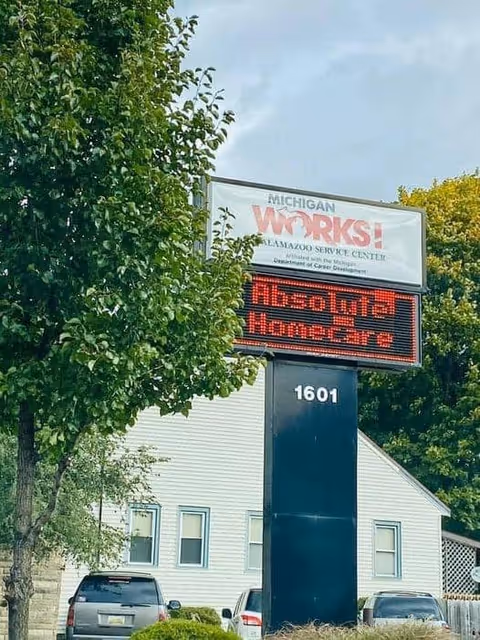 Exterior view of Absolute Homecare and Medical Staffing sign beside a tree-lined building.