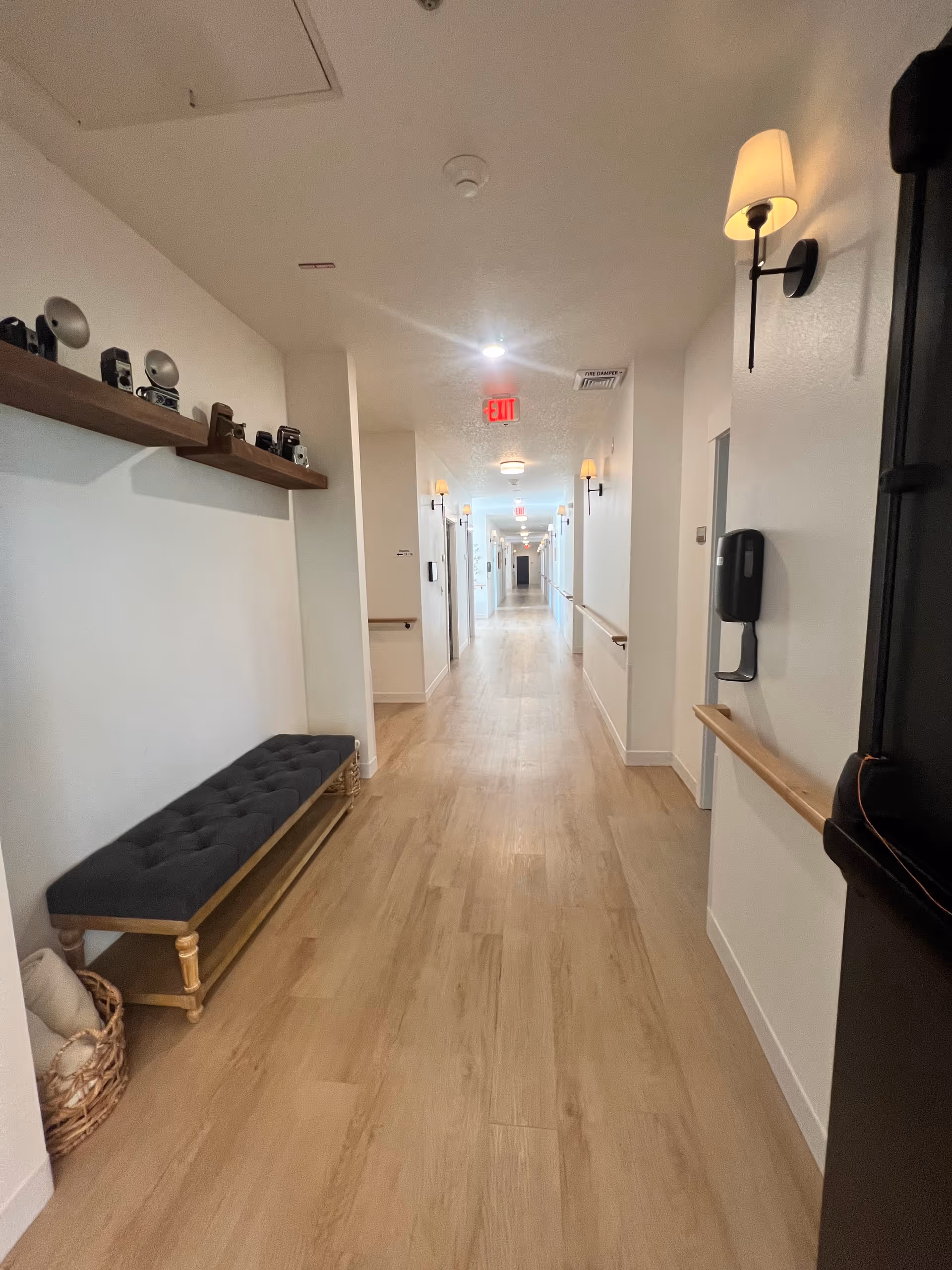 Bright hallway inside Lacamas Heights Memory Care with a bench along the wall.