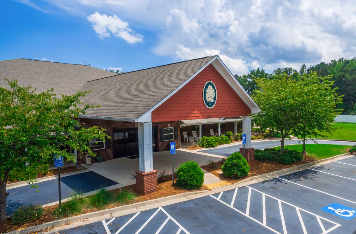 Front exterior view of Oaks at Post Road with entrance, trees, and handicap parking.