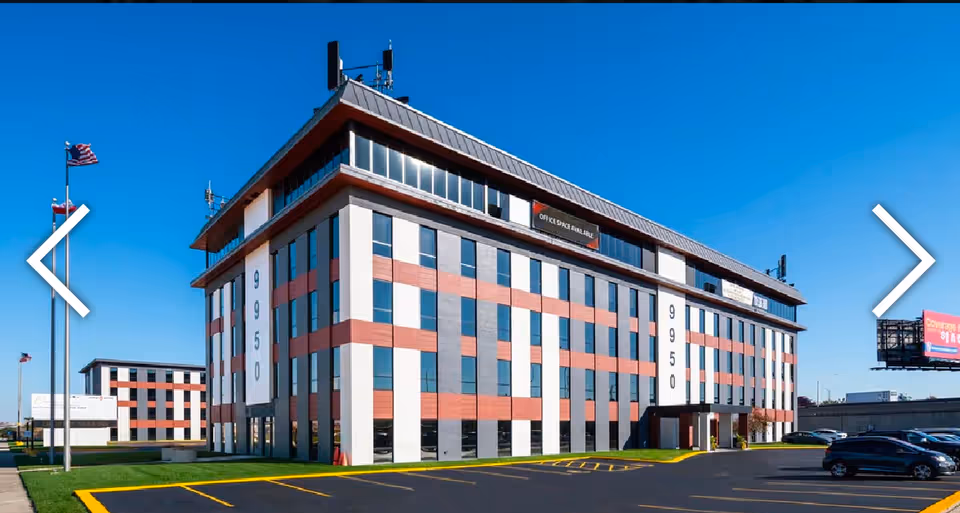 A modern multi-story Happyian senior living facility building with red-and-white facade against a blue sky.