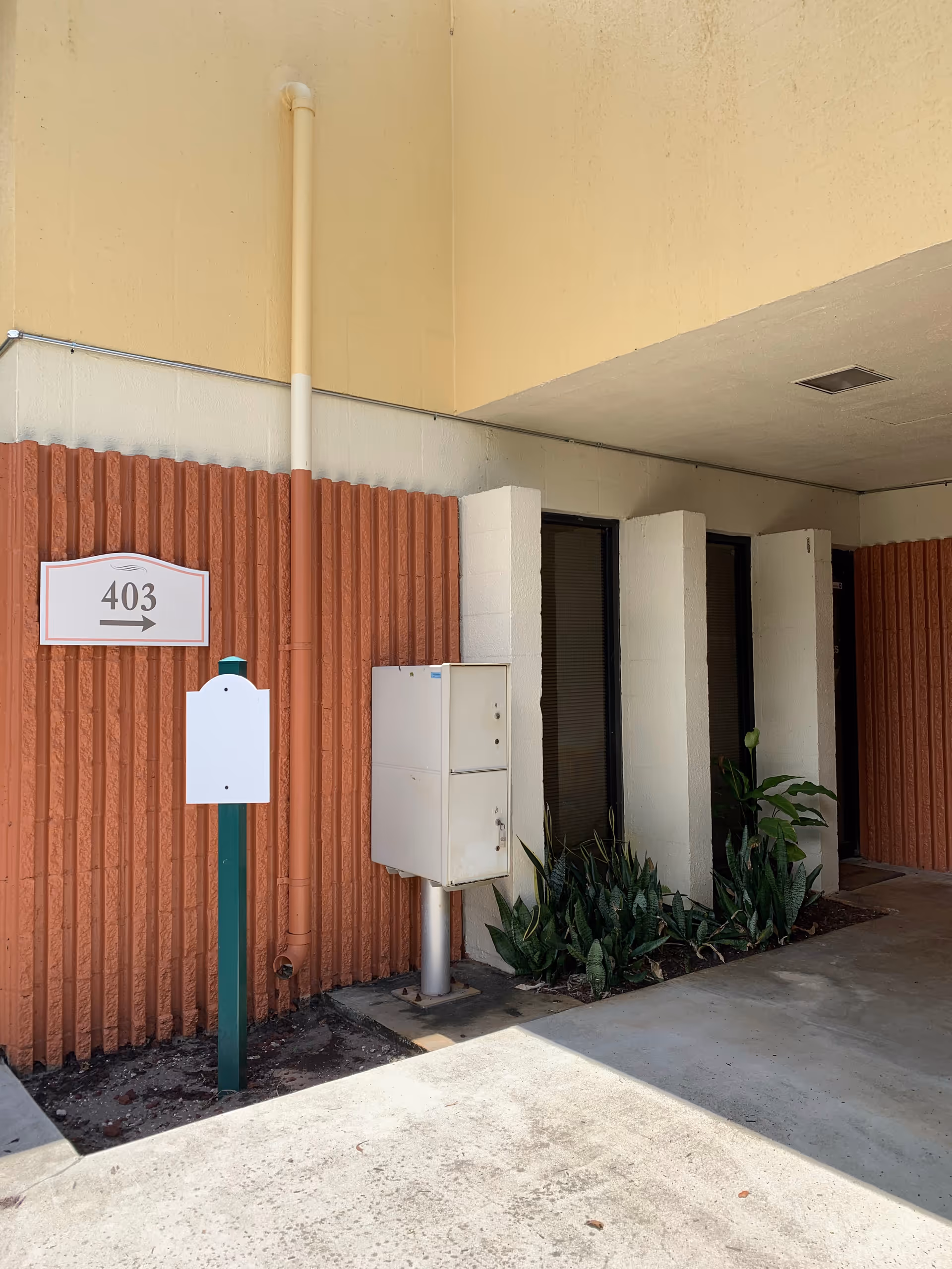 Exterior view of the facility entrance with a 403 sign and mailbox.