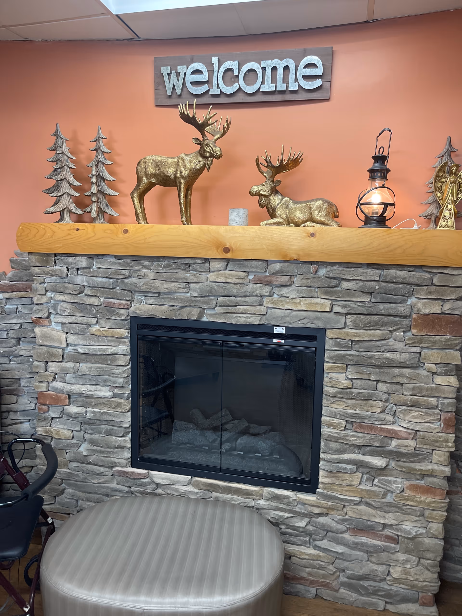 Stone fireplace with wooden mantel and holiday decor in a cozy living room.