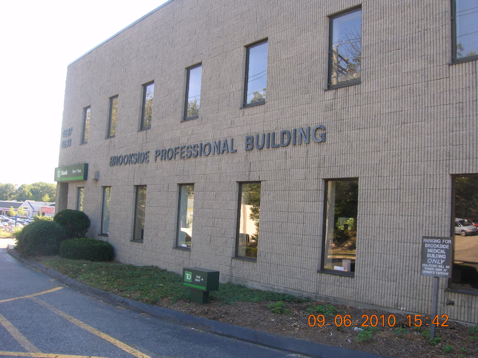 Exterior view of Brookside Professional Building with windows and a parking lot.