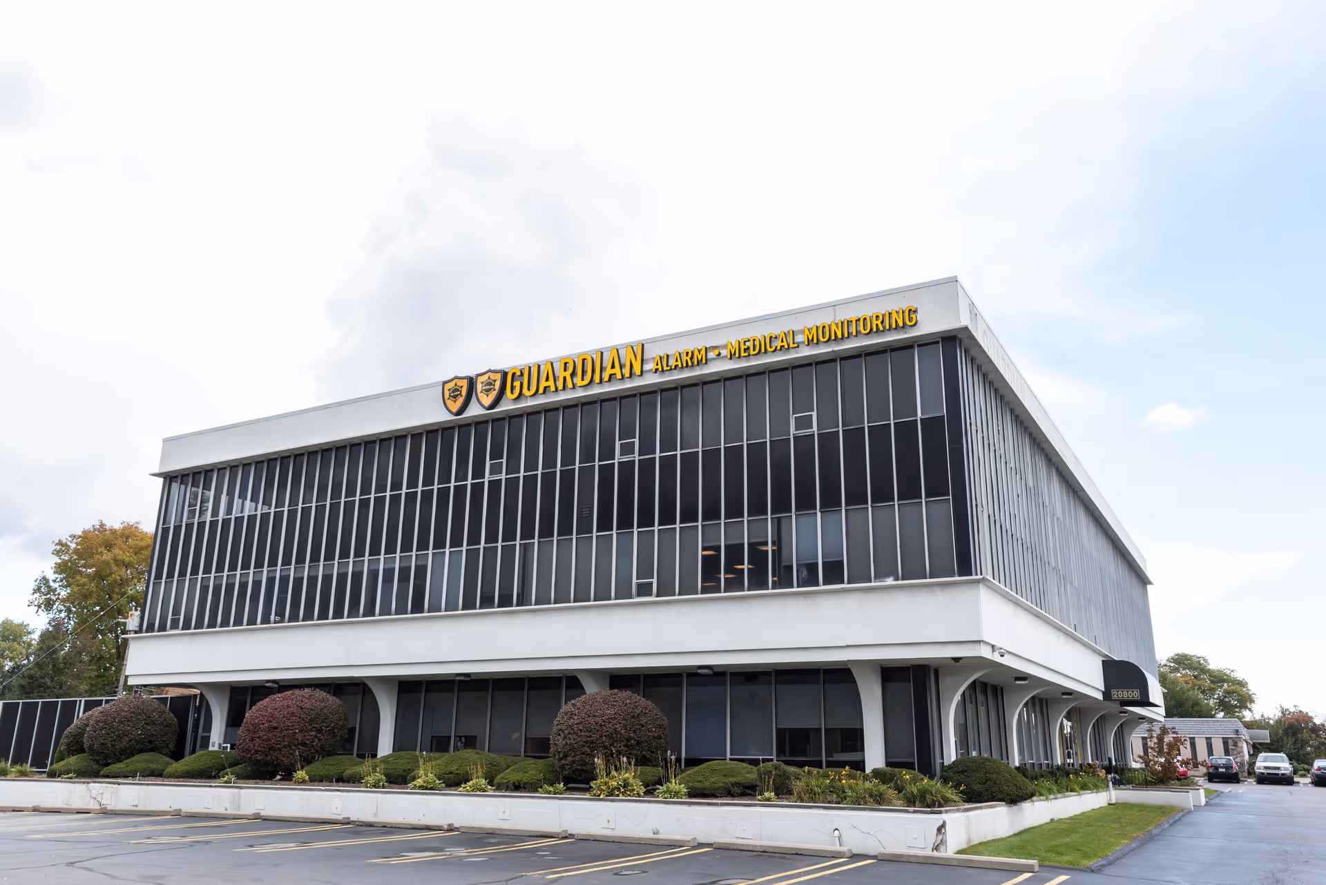 Guardian Medical Monitoring building front with glass windows and a landscaped parking area.