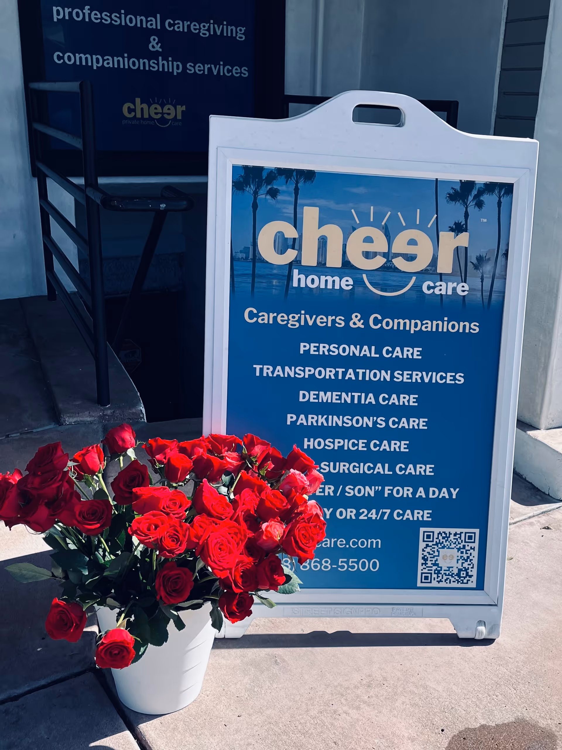 Blue Cheer Home Care sign outside entrance with a bouquet of red roses.