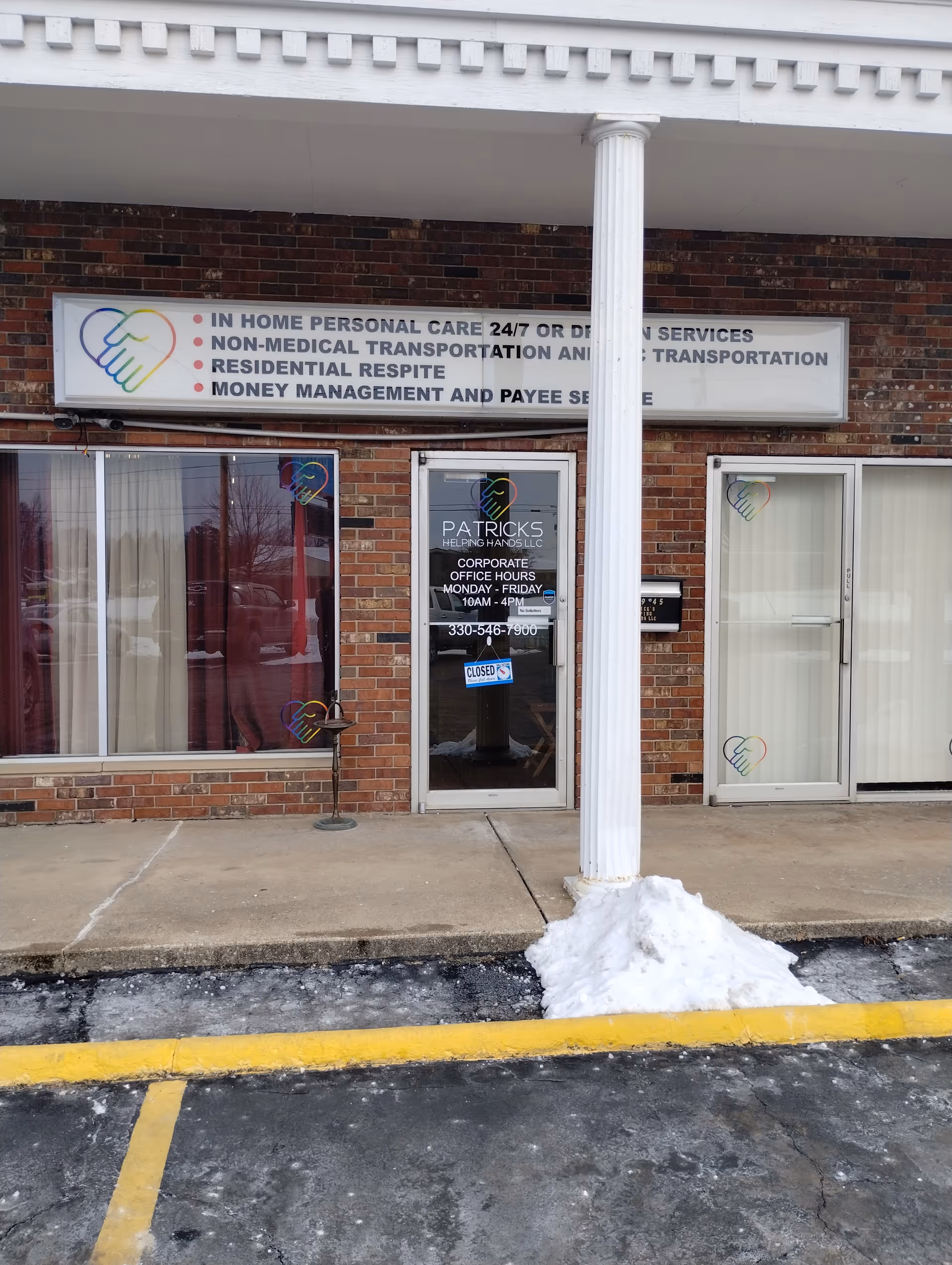 Brick storefront with signage for Patrick's Helping Hands LLC and glass doors.