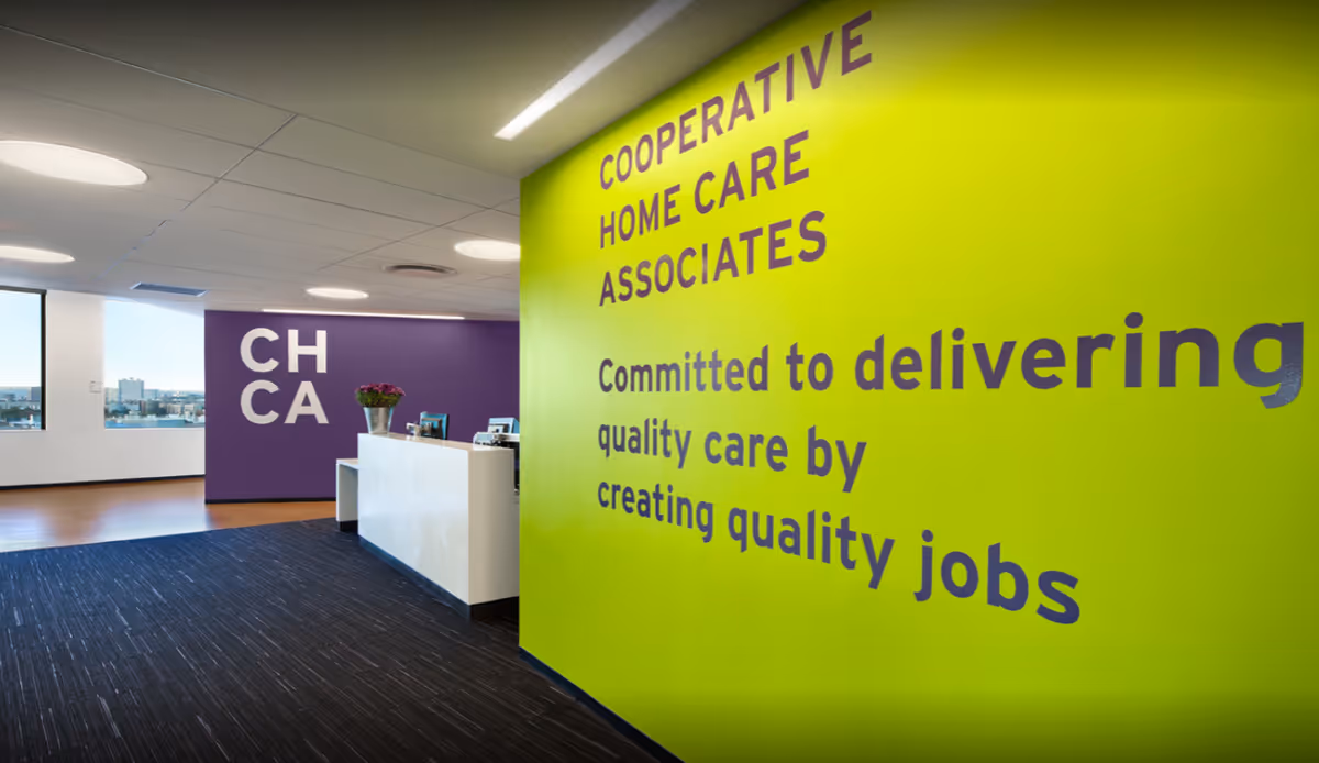 Reception area inside Cooperative Home Care Associates featuring lime green wall and purple accent.
