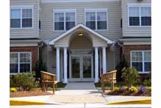 Oaks of Wellington entrance features a small front porch with columns and glass doors.