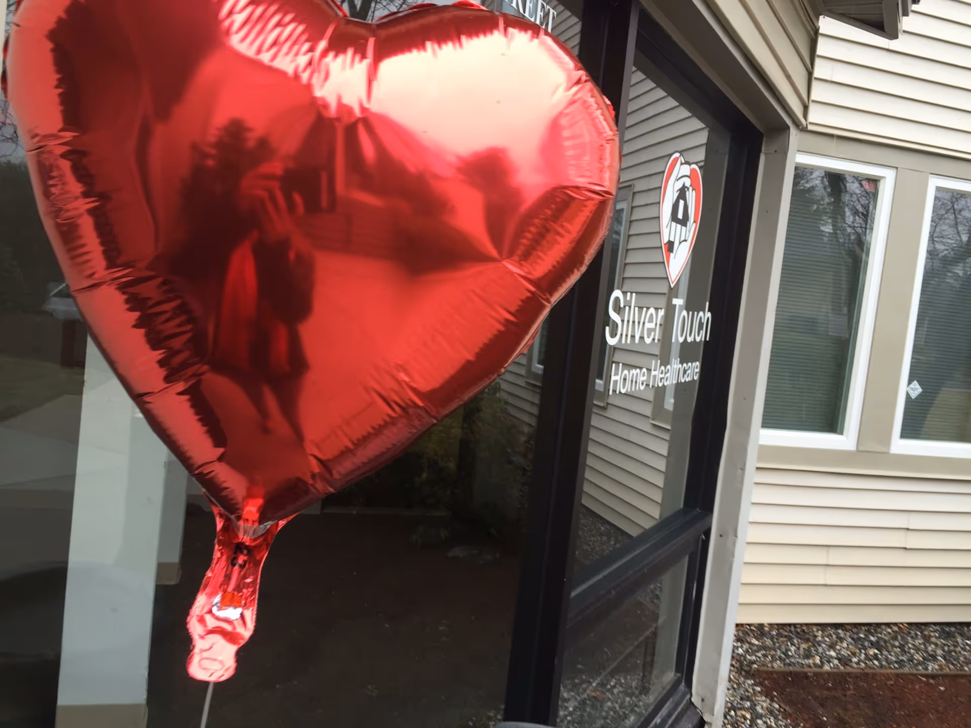 Entrance of Silver Touch Home Health Care building with a large red heart balloon.
